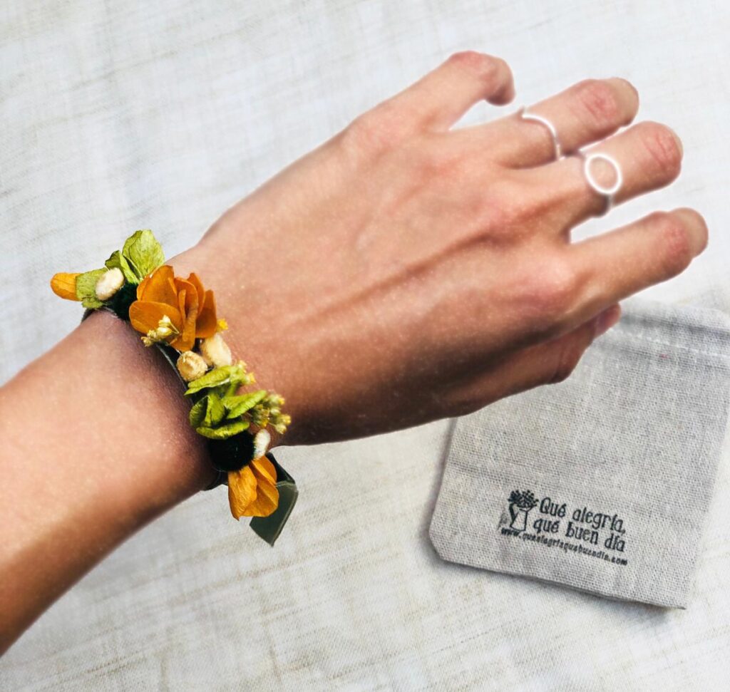 Foto de una pulseras flor preservada en la mano para regalar a testigos