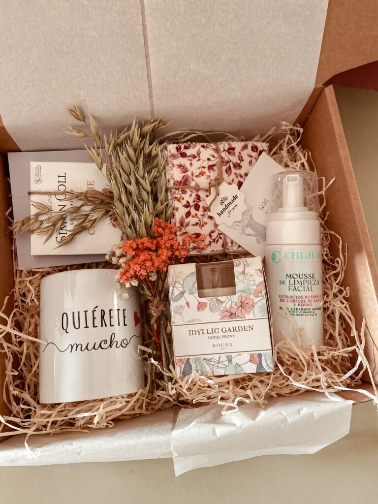 Pack Regalo Disfruta del Momento. Incluye una taza, chocolate, velas, productos de cosmetica. Flores