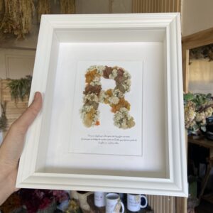 Inicial de flores preservadas en cuadro