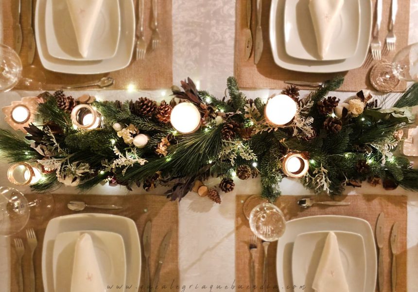 Decoracion Mesa Navidad compuesta por diferentes ramas verdes, velas, piñas, y más elementos decorativos.