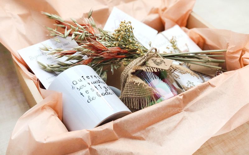 Pack regalo bodas compuesto por taza, chuches, chocolate, libreta kraft y decoración extra.